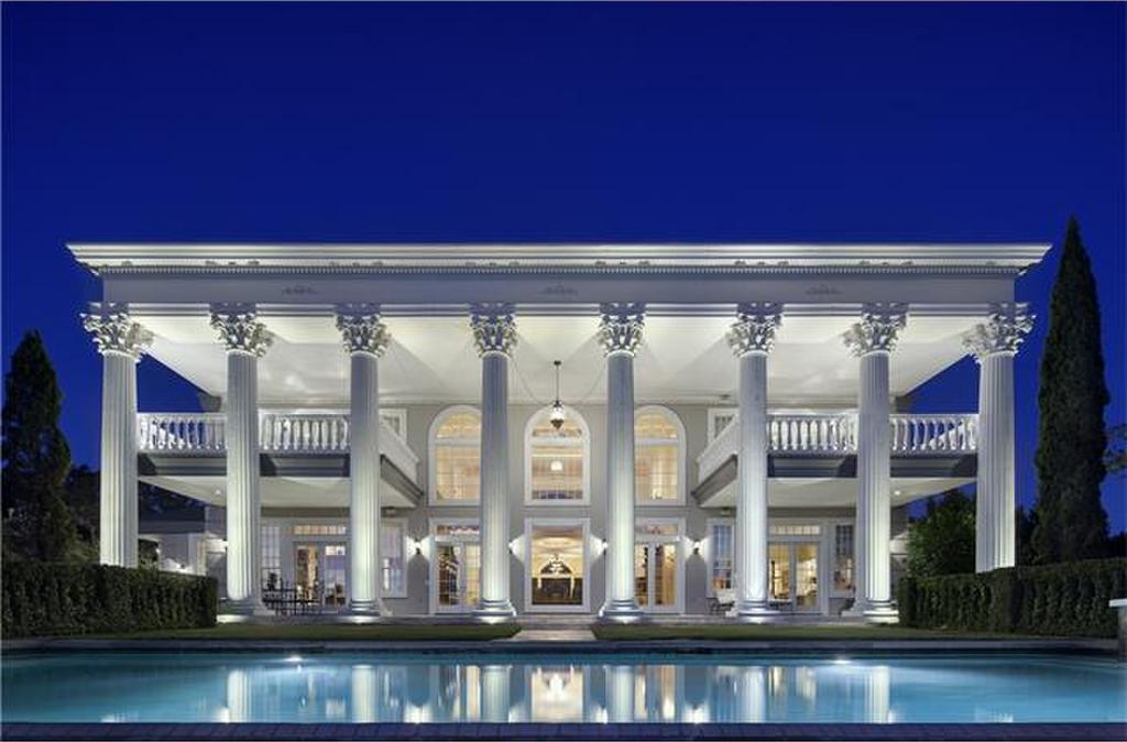 front elevation of austin mansion with white pillars and reflecting pool