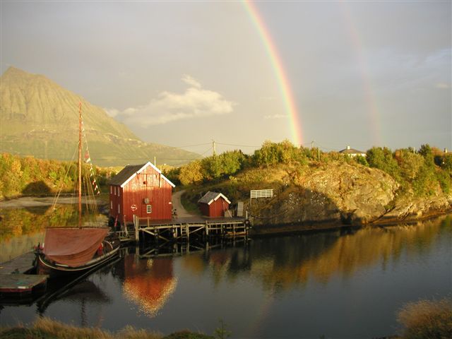 fishing boat docked on krokholmen island with rainbow overhead