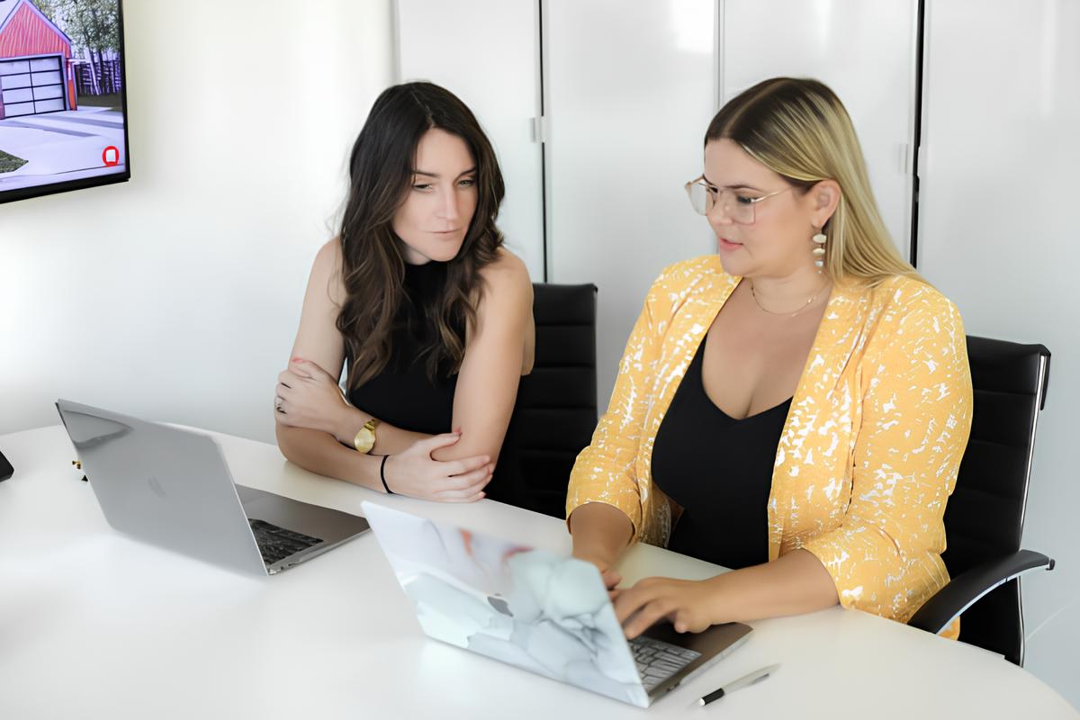 Two agents sitting together with laptop
